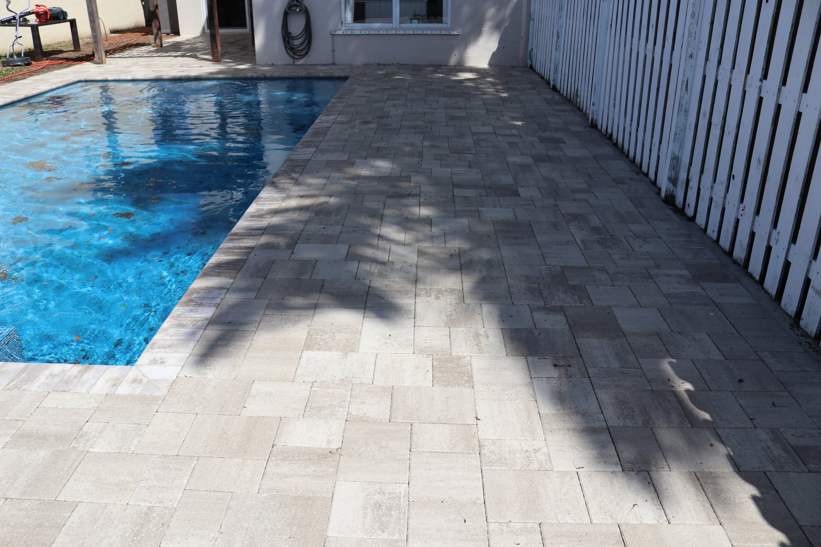 Pool deck pavers after tannin removal and soft wash — clean restored finish
