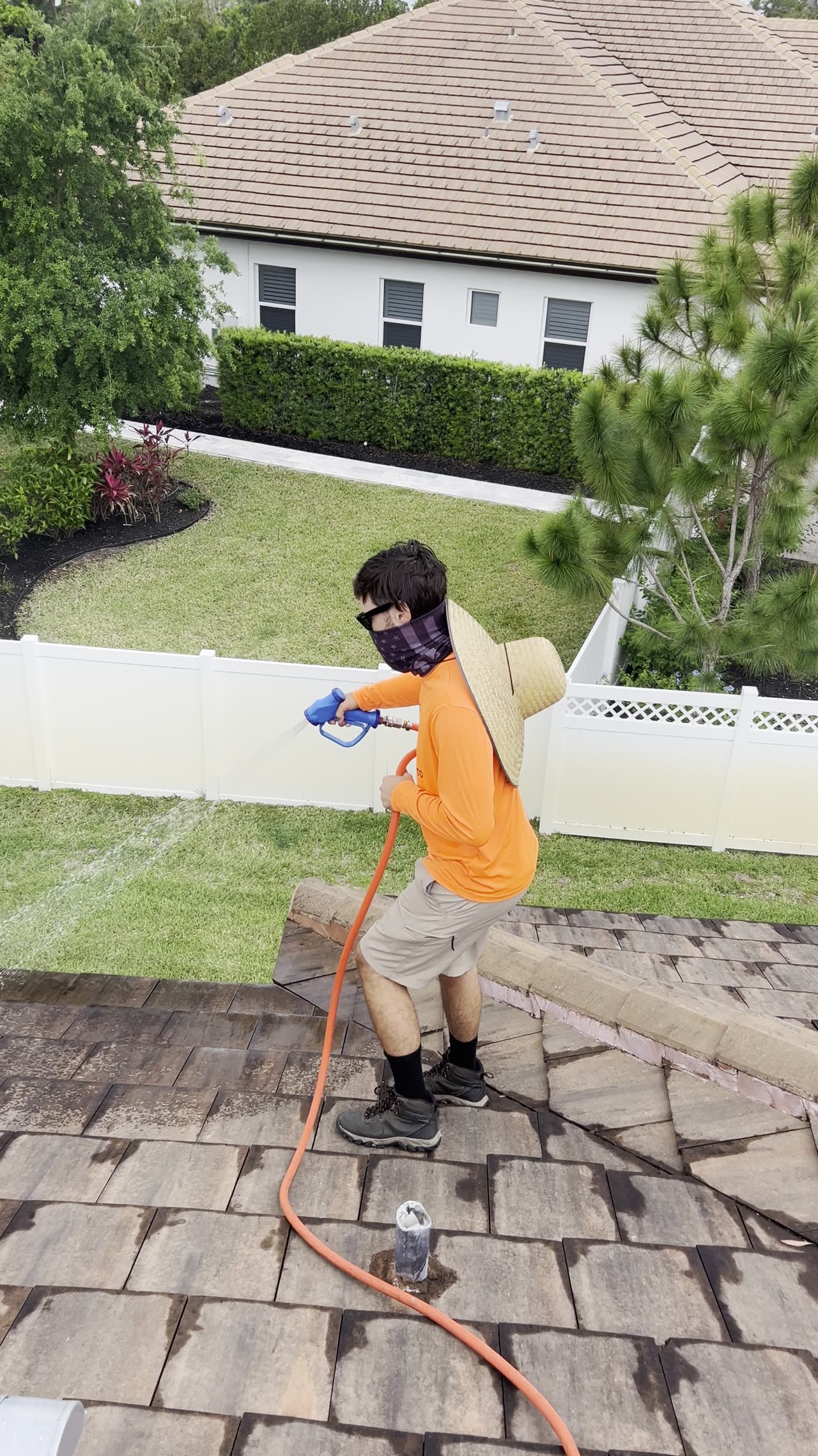 Worker performing soft wash treatment on exterior surface